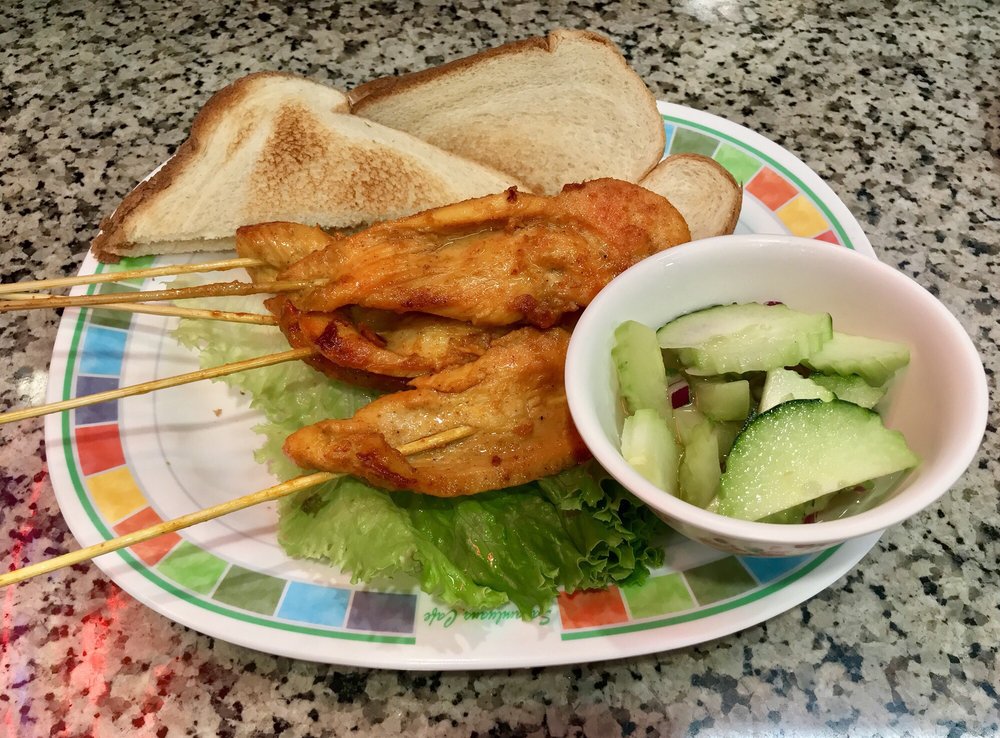 Chicken satay skewers with toast and cucumber salad