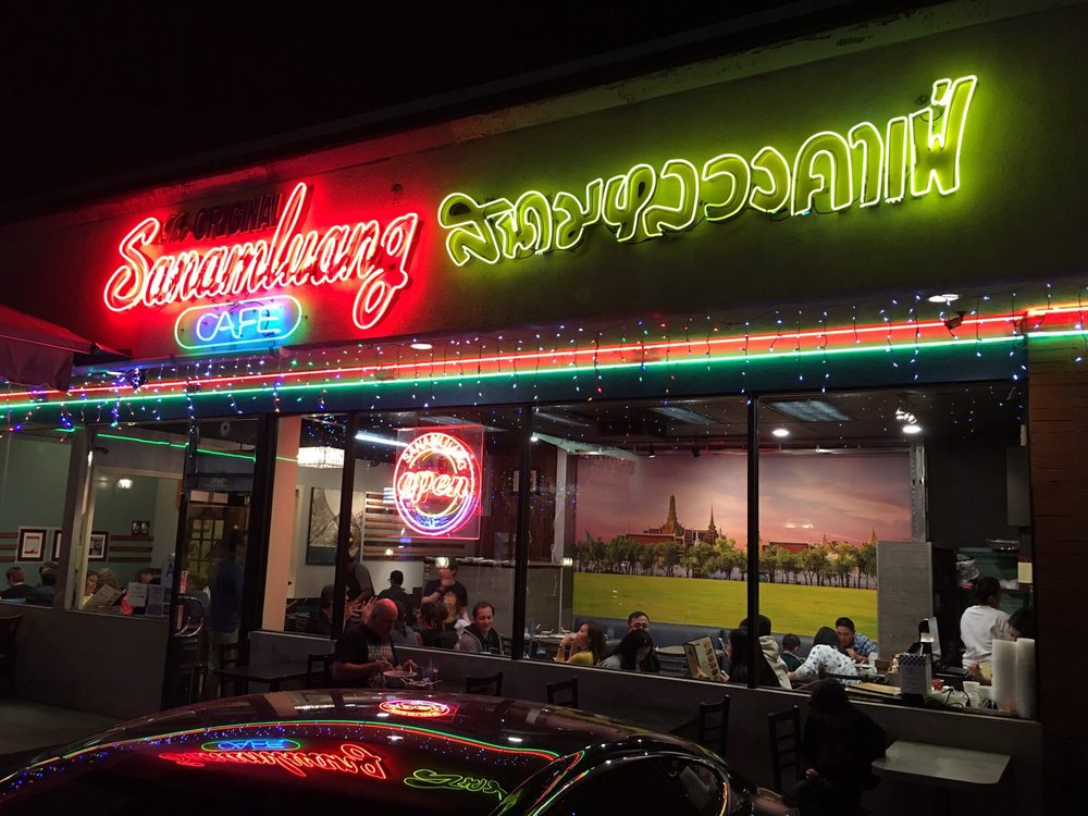 Sanamluang Cafe's neon sign in English and Thai over the Hollywood Boulevard storefront at night