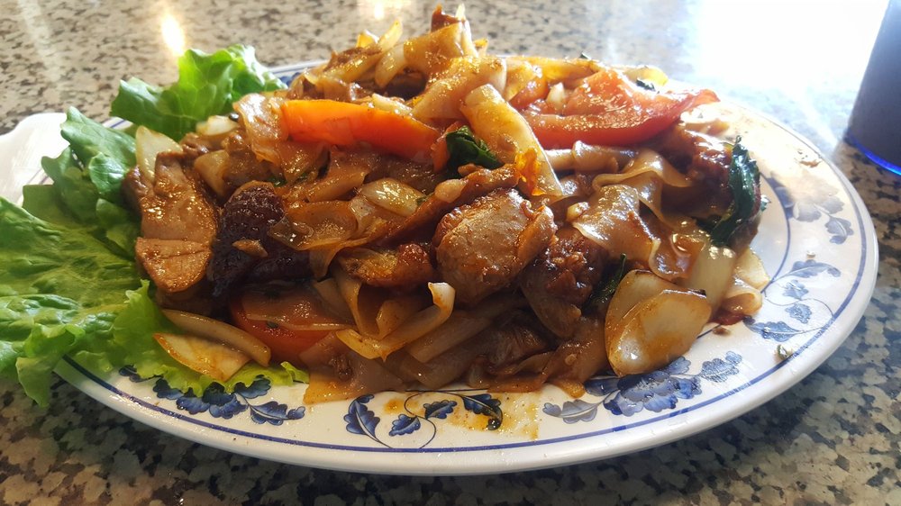 Wide rice noodles stir-fried with beef, carrots and basil